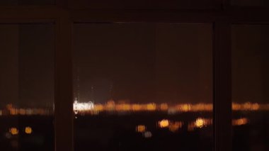 Bir gece fırtınasının yavaş çekim videosu. Pencerede yıldırım ve yağmur damlaları sergileniyor. Hava durumu, sükunet ve doğal güzellik temaları için idealdir. Sinema ve yaşam tarzı promosyonları için mükemmeldir.. 