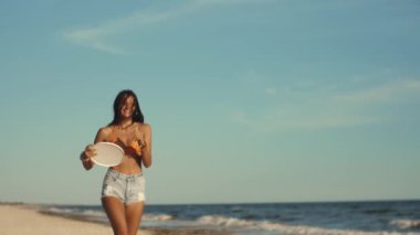 Bronzlaşmış bir Asyalı model, güneşli bir plajda frizbiyi yavaş çekimde fırlatır, kaygısız bir hippi yaşam tarzını somutlaştırır. Bu sinematik, yüksek kaliteli görüntü seyahat tanıtımları, yaşam tarzı blogları ve...