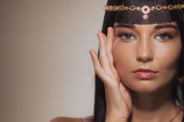 Kleopatra 'dan esinlenilmiş makyajlı, bronz tenli, altın başlıklı, güzelliğini ve zarafetini ön plana çıkaran büyüleyici bir kadın portresi. Moda, kültür ve...