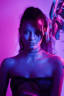 Etkileyici ve büyüleyici bir Asyalı kadın portresi neon ışıklarla yıkanmış, gece kulübü atmosferi yaratıyor. Moda, reklam ve tanıtım amaçlı kullanım için ideal, bu yüksek kaliteli görüntü.