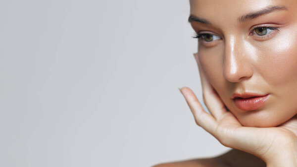 Крупный план красивой женщины с безупречной кожей, нежно касающейся лица. Идеально подходит для рекламы кожи и косметики, рекламы и высококачественных концепций красоты.