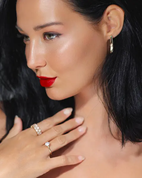 stock image Sophisticated Asian woman with bold red lips and luxury jewelry, featuring elegant evening makeup. Ideal for high-end beauty, fashion, and jewelry promotions, highlighting glamour and sophistication.