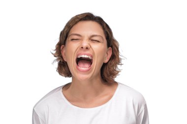 Yoğun bir ifadeye sahip bir kadın beyaz bir arkaplan karşısında tutkuyla bağırıyor, güçlü bir duygu ve enerji anı yakalıyor. Reklamlar, promosyon materyalleri ve kampanyalar için ideal.