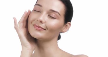 Asyalı güzellik modeli. Bir kadının elinin, pürüzsüz ve parlak tenine nazikçe dokunduğu ve kusursuz cildini ön plana çıkardığı yakın plan bir fotoğraf. Cilt bakımını teşvik etmek için mükemmel, güzellik