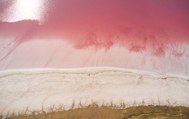 Pembe tuzlu bataklıktaki insansız hava aracından inanılmaz bir manzara. Kuşbakışı bakış açısından soyut bir doku. Hava fotoğrafçılığı. Syvash Gölü, Ukrayna, Avrupa. Toprağın güzelliğini keşfedin.