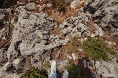 Yukarıdan bakıldığında, Türkiye 'nin Antalya kentindeki engebeli kayalık arazide duran bir kişinin macera ve keşfin özünü yakaladığı görülüyor. Yürüyüş, seyahat ve açık hava temaları için mükemmel..