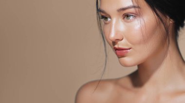Parlak tenli, stüdyo ortamında poz veren güzel bir Asyalı kadının yakın çekimi. Güzellik, cilt bakımı ve kozmetik reklamları için ideal. Kavramsal ve promosyonal kullanım için yüksek kaliteli resim.
