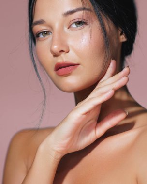 Kusursuz ciltli, minimalist bir ortamda poz verirken zarafet saçan büyüleyici bir genç kadın görüntüsü. Güzellik, cilt bakımında veya doğal ve sağlıklı kampanyalarda kullanılmak için idealdir.