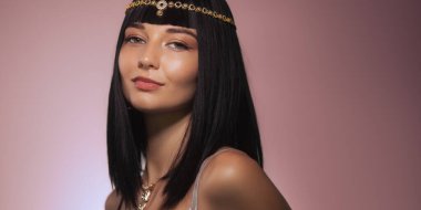 Siyah saçlı, altın başlık takan ve zarif poz veren zarif bir kadın. Moda, güzellik ve yaşam tarzı promosyonları ve zarafet ve stili vurgulayan reklamlar için mükemmel.