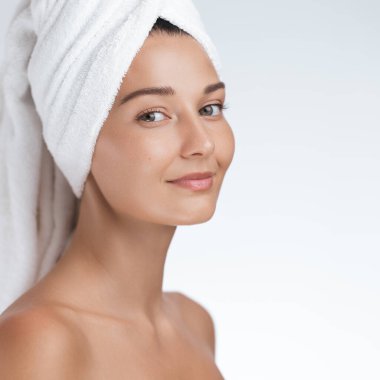 Güzellik tedaviden sonra havluya sarılmış çekici genç bir kadın, berrak, pürüzsüz bir cilt ve sakin bir kaplıca ortamı sergiliyor. Sağlık, güzellik ve cilt bakımı için mükemmel promosyonlar veya reklamlar için.