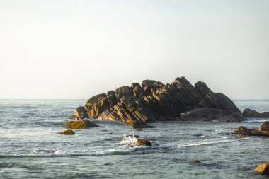 Sri Lanka 'daki Galle Kalesi' nin yakınlarında, gün batımında yakalanan engebeli kayalık bir çıkıntı okyanustan çıkar. Sakin dalgalar ve huzurlu bir kıyı manzarası yaratıyor. Doğa ve seyahat temaları için mükemmel.