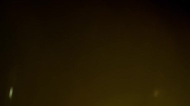 Soyut bir gerçek mercek, koyu bir arkaplana karşı yumuşak, sinematik bir ışıltıyla örtüşür. Bu ışıklandırma efekti ince, rüya gibi bir atmosfer yaratarak görsel efektler, filmler ve