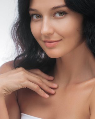 Gülümseyen, uzun siyah saçlı, kusursuz tenli, elini omzuna koyan Asyalı bir kadının yakın çekimi. Güzellik, cilt bakımı ve kozmetik reklamları için ideal.