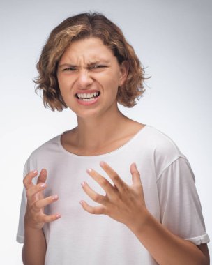 Çığlık, nefret, öfke. Mavi stüdyo arka planında ağlayan duygusal sinirli kadın. Duygusal, genç yüz. Yarım boy kadın portresi. İnsani duygular, yüz ifadesi kavramı. Moda renkleri