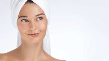 Genç bir kadın cilt bakımını tamamladıktan sonra havluya sarılırken nazikçe gülümsüyor. Güzelliği, sağlığı, cilt bakımını ve sağlıklı cilt bakımını teşvik etmek için mükemmel.