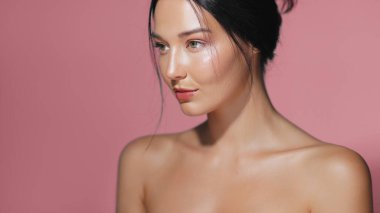 Pembe bir arka planda poz veren sulu derili zarif bir kadının portresi. Güzellik, cilt bakımı ve kozmetik konsepti reklamları ve yüksek kaliteli promosyon malzemeleri için ideal.