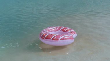 Beyaz bikinili bir kadının pembe donut şeklindeki şişirilebilir donutunu kaçırarak suya atladığı neşeli bir an. Eğlenceli, hayat dolu bir sahne. Yaz ve tatil temaları için mükemmel.. 