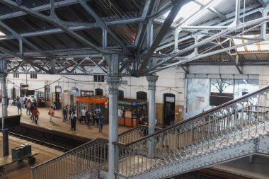 Colombo tren istasyonunda canlı bir sahne merdiven, platform ve yolcuları gösteriyor. Endüstriyel mimariyle hareketli bir ulaşım merkezinin enerjisini yakalıyor.. 