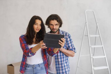 Tablete bakan ciddi bir çift DIY ev yenileme projesi planlıyor. Ev geliştirme, iç tasarım ve yaratıcı projelerle ilgili kavramlar için mükemmel.. 