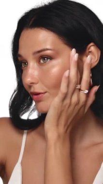 Parlak derili şık bir kadın zarif takılar takarken makyajını düzeltiyor. Güzellik, cilt bakımı ya da lüks ürün kampanyaları ve promosyonları için mükemmel bir stüdyo çekimi.. 