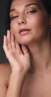 Kendine güvenen, parlak tenli, zarif halka küpeler takan bir kadının yakın çekimi. Onun pürüzsüz cildi ve ince makyajı onun doğal güzelliğini ön plana çıkarıyor, bu görüntüyü güzellik ve moda için ideal kılıyor.