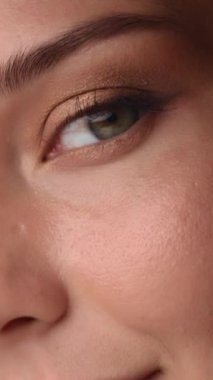 Kusursuz derisi ve ince altın göz farı olan, doğal güzelliği ve makyaj detaylarını vurgulayan bir kadının aşırı yakın çekimi. Güzellik kampanyaları, kozmetik reklamları ve cilt tanıtımları için ideal.