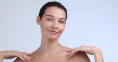 Kusursuz, parlak bir cildi olan, köprücük kemiğini nazikçe çerçeveleyen gülümseyen bir kadının yakın çekimi. Güzellik ürünleri promosyonları, cilt bakımları ve lüks spa tedavileri için mükemmel.. 