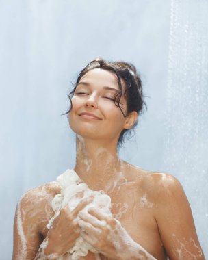 Sabun köpüğüyle kaplı, rahatlatıcı duşun keyfini çıkaran rahat bir kadının yüksek kaliteli yakın çekim görüntüsü. Refah, cilt bakımı ve barışçıl rahatlama kavramlarını desteklemek için mükemmel..