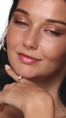 Parlak mücevherler, pürüzsüz bir ten ve doğal makyaj sergileyen bir kadının zarif stüdyo portresi. Güzellik, moda ya da lüks reklamlar için ideal. Zarafet ve cazibeyi ön plana çıkarıyor.. 