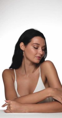 Doğal makyajlı, parlak tenli, altın küpeli beyaz bluzlu, kendine güveni ve zarafeti olan şık bir kadın. Güzellik, cilt bakımı ve moda terfileri için mükemmel.. 