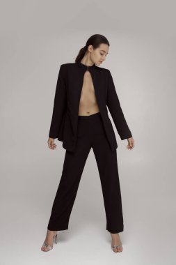 Açık siyah ceketli, gömleksiz, kendine güvenen genç bir kadın. Moda, yazı işleri ya da minimalist yaşam tarzı kavramları için mükemmel.. 