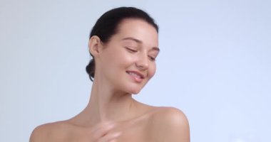 Parlak tenli sakin bir kadının portresi, gülümserken nazikçe omzuna dokunuyor. Güzellik, özgüven, sağIık ve cilt bakım kampanyaları için ideal.. 