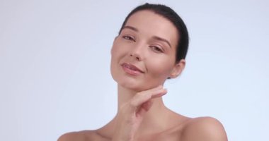 Zarif genç bir kadın doğal makyaj ve kusursuz ciltle poz verir. Güzellik, sağlık, cilt bakımı, yaşlanma karşıtı veya spa temalı reklam ve editoryal kullanım için mükemmel. 