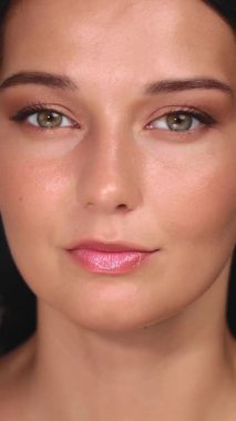 Kusursuz derisi, ince göz makyajı ve parlak dudakları olan bir kadının çarpıcı yakın plan portresi. Kendine güveni ve ışıl ışıl teni bunu güzellik, cilt bakımı ve kozmetik için mükemmel kılıyor.