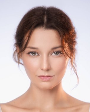 Beyaz tenli, az makyajlı ve hafif ışıklandırmalı beyaz bir kadının portresi. Cilt bakımı, doğal güzellik, kozmetik ve sağlık reklamları için mükemmel..