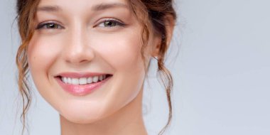 Parlak cildi, doğal makyajı ve parlak dudakları olan neşeli beyaz bir kadının parlak yakın çekimi. Güzellik, cilt bakımı, diş bakımı ve sağlık yaşam tarzı reklamları için mükemmel..