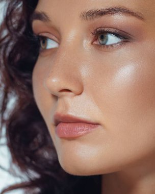 Pürüzsüz, parlak bir cilde, göze hoş gelen bir makyaja ve sağlıklı dudaklara sahip bir kadına yakından bakın. Cilt bakımları, kozmetik ürünleri ve moda kampanyaları için çok kaliteli bir görüntü..