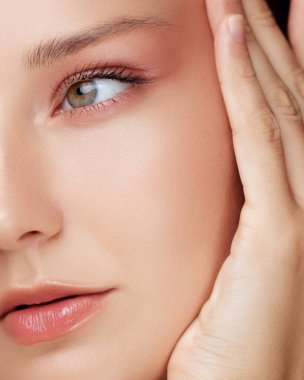 Sağlam ciltli, şeftali makyajlı ve parlak dudaklı bir kadının makro portresindeki göz kaldırma efektini gösteren güzellik konsepti. Yaşlanma, göz bakımı ya da kozmetik cilt bakımı kampanyaları için mükemmel..