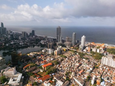 Colombo 'nun hava fotoğrafı modern okyanus manzaralı gökdelenler ve geleneksel evlerin karışımını gösteriyor. Kentsel planlama, gayrimenkul, kalkınma ve seyahat görselleri için yüksek kaliteli görüntü ideal.