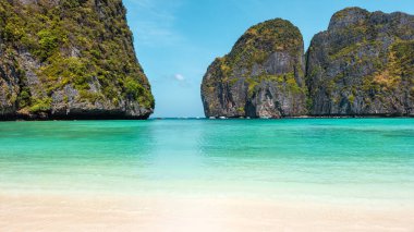 Büyüleyici yatay manzara Tayland 'ın Koh Phi Phi plajındaki büyüleyici Maya Körfezi plajını gösteriyor. Bu nefes kesici manzara yumuşak beyaz kumlar, canlı turkuaz sular ve dramatik kireçtaşı içerir.
