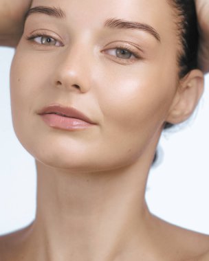 Genç beyaz bir kadının portresi. Parlak, sağlıklı bir teni, az makyajı ve doğal bir güzelliği var. Cilt bakımı için ideal, temiz güzellik, ve sağlık promosyon içeriği.