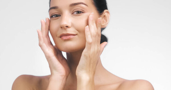 High-quality beauty concept featuring a woman massaging her face with a calm, confident look and glowing skin. Perfect for wellness ads, facial treatment branding, and skincare visuals.