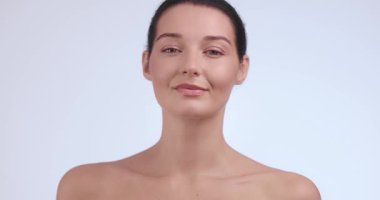 Güzel genç bir kadın cilt bakımıyla nazik bir yüz masajı yapıyor. Lüks kozmetik reklamları, güzellik rutinleri, sağlık ve kişisel bakım videoları için mükemmel..