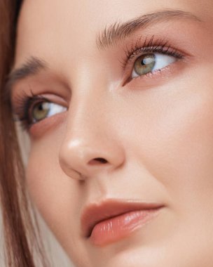 Kusursuz cilt, yumuşak şeftali makyajı ve doğal ışıltıdan oluşan bir kadının aşırı yakın çekimi. Üst düzey cilt bakımı, makyaj ve kozmetik ürün reklamcılığı için mükemmel..