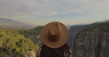 Şapkalı bir kadın, Türkiye 'nin Tazi Kanyonu' ndaki manzaranın keyfini yavaş çekimde sürüyor. Seyahat, doğa ve macera teması için mükemmel, konumun güzelliğini ve huzurunu vurguluyor.. 