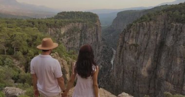 Türkiye 'deki çarpıcı Tazi Kanyonu' na bakan romantik bir çift el ele tutuşuyor. Seyahat, macera ve romantizm teması için mükemmel. Konumunun güzelliğini ve samimiyetini gözler önüne seriyor.. 