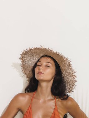 Hasır şapkalı bronz tenli bir kadının güneş ışığının tadını çıkarırken, güzellik konsepti, rahatlama, cilt bakımı, kaplıca tanıtımı veya yaz yaşam tarzı, temiz, yüksek kaliteli görüntü..