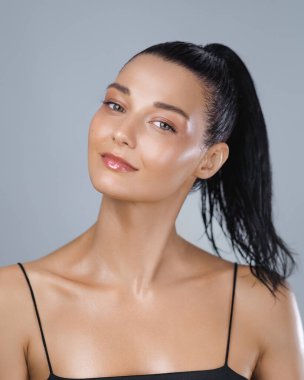 Beyaz tenli, parlak tenli ve spor sonrası kendine güvenen bir kadın. Cilt bakımı, sağlık, güzellik ve aktif yaşam tarzı reklam temaları için yüksek kaliteli stüdyo portresi.