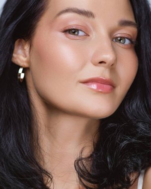 Işıl ışıl cildi, yumuşak makyajı ve koyu renk saçı olan güzel bir kadının yüksek kalite yakın çekimi. Güzellik, cilt bakımı, kaplıca, kozmetik reklamları ve temiz promosyon tasarımları için ideal..