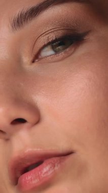 Zarif makyajlı ve parlak tenli beyaz bir kadın modelin kavramsal yakın çekimi. Güzellik reklamlarında, cilt bakımında, reklamlarda, afişlerde ya da editoryal içerikte kullanım için mükemmel.